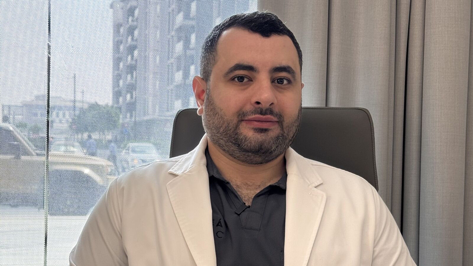 Dr. Hossam Mohammed at his desk at Soleá Clinic, Dubai